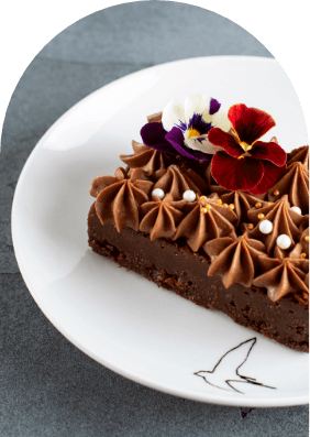 Rich chocolate cake with edible flowers — dessert at Taste of Istanbul Turkish restaurant Dubai