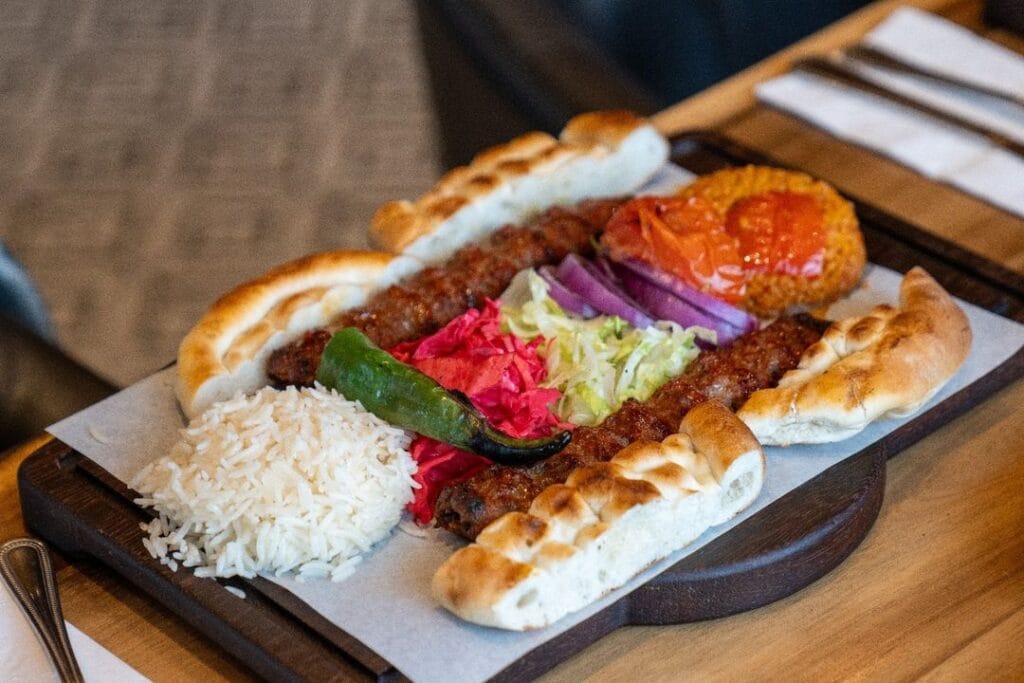 Adana kebab with rice, grilled tomato and flatbread at Taste of Istanbul Dubai